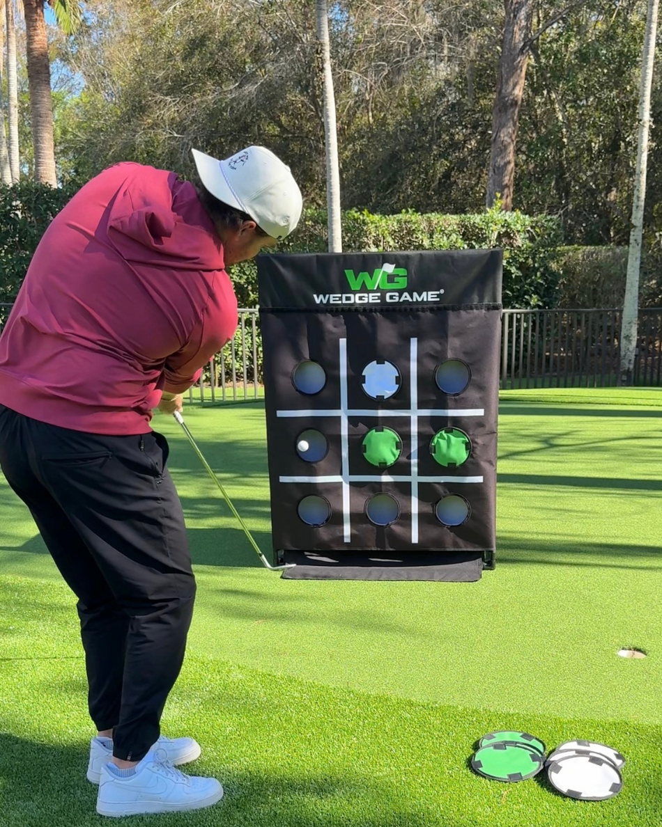 Person practicing golf shots at a wedge game tic-tac-toe target panel