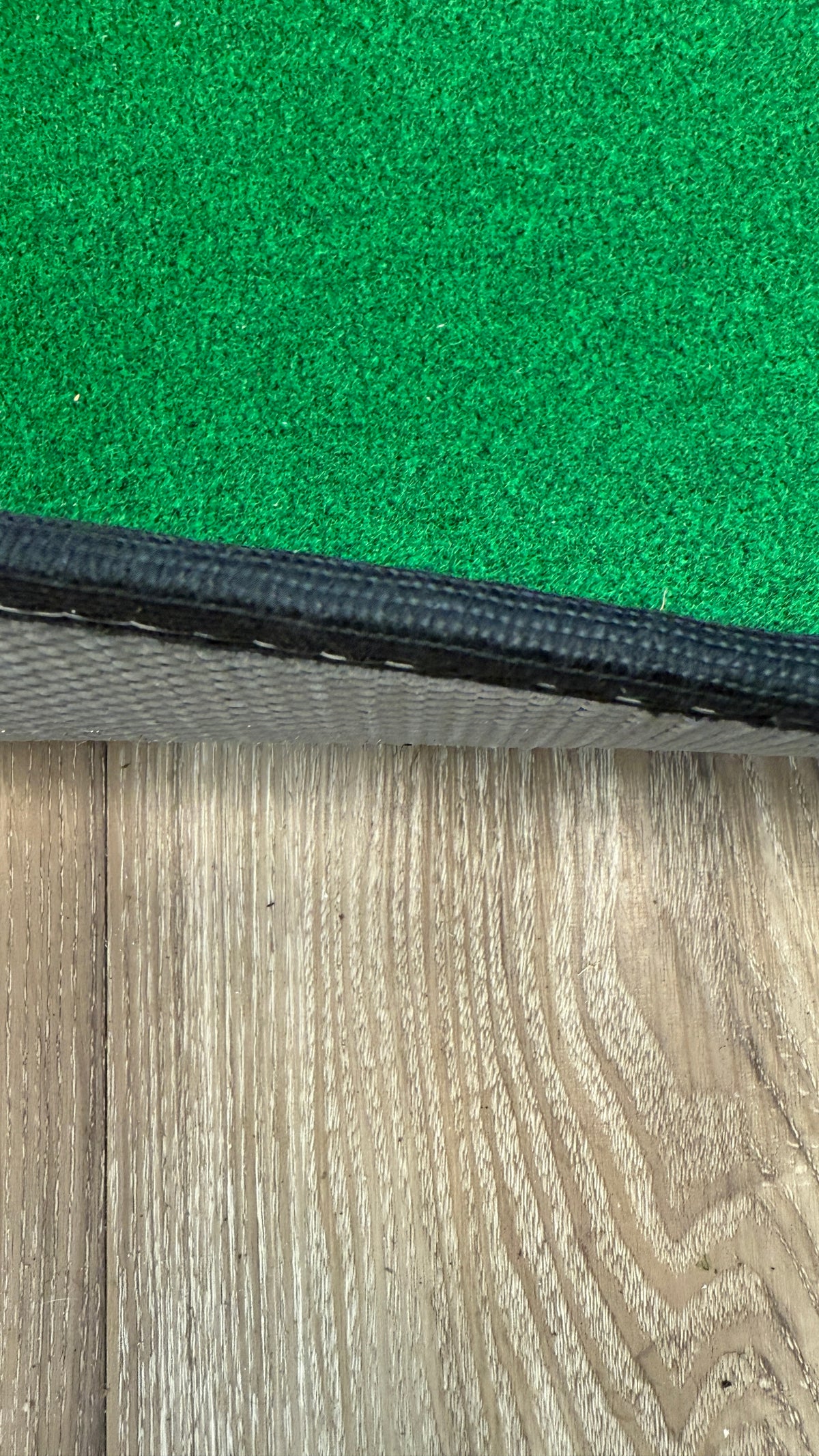 Wedge Game putting mat thickness showing on a wood floor