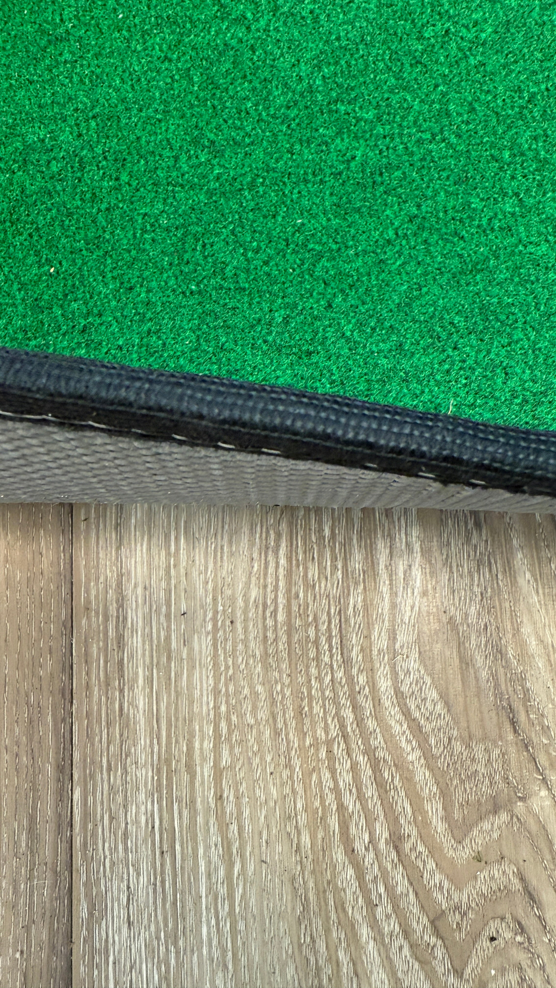 Wedge Game putting mat thickness showing on a wood floor
