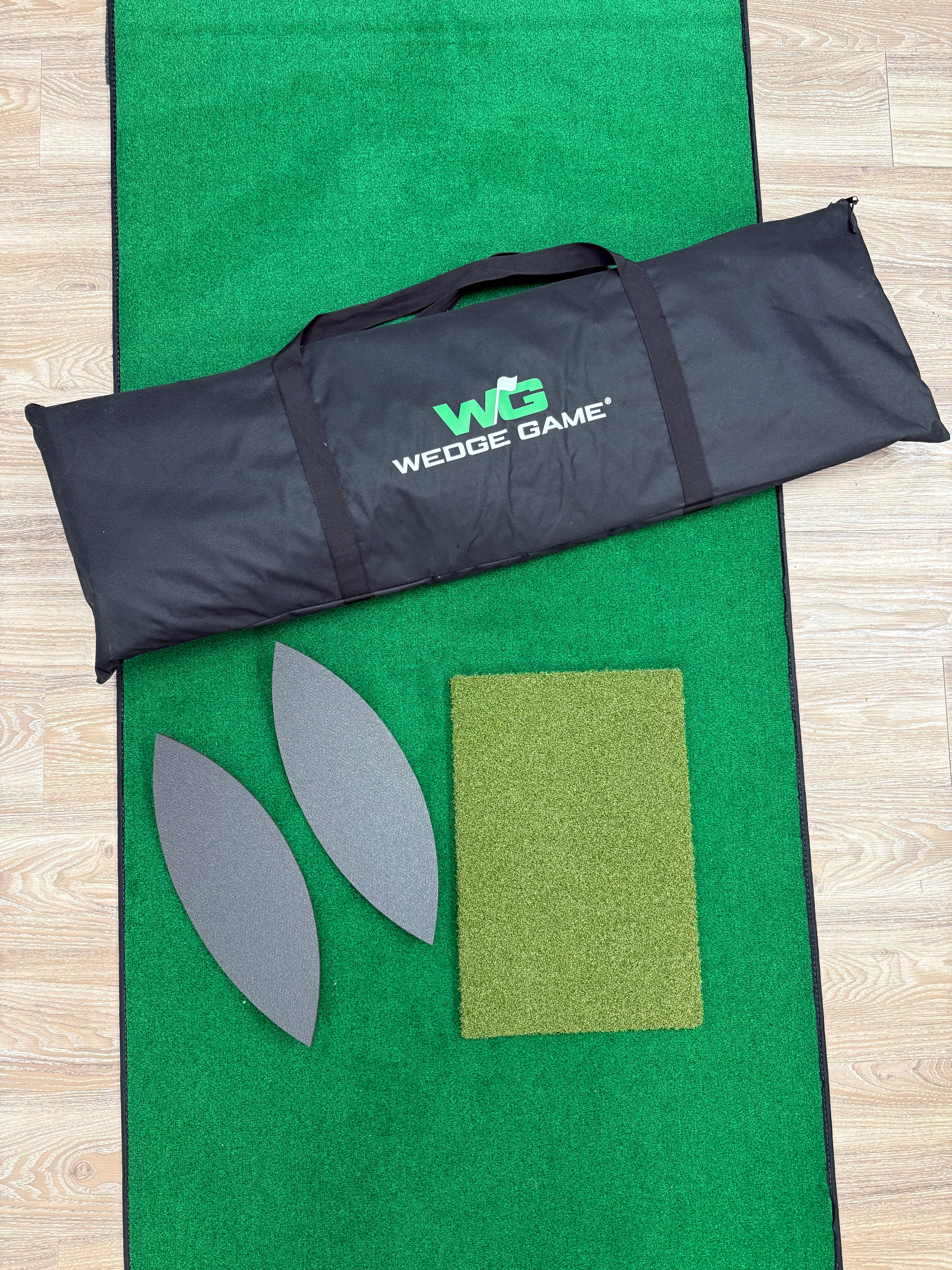 Black wedge game carrying case on a green golf practice mat with wedges.
