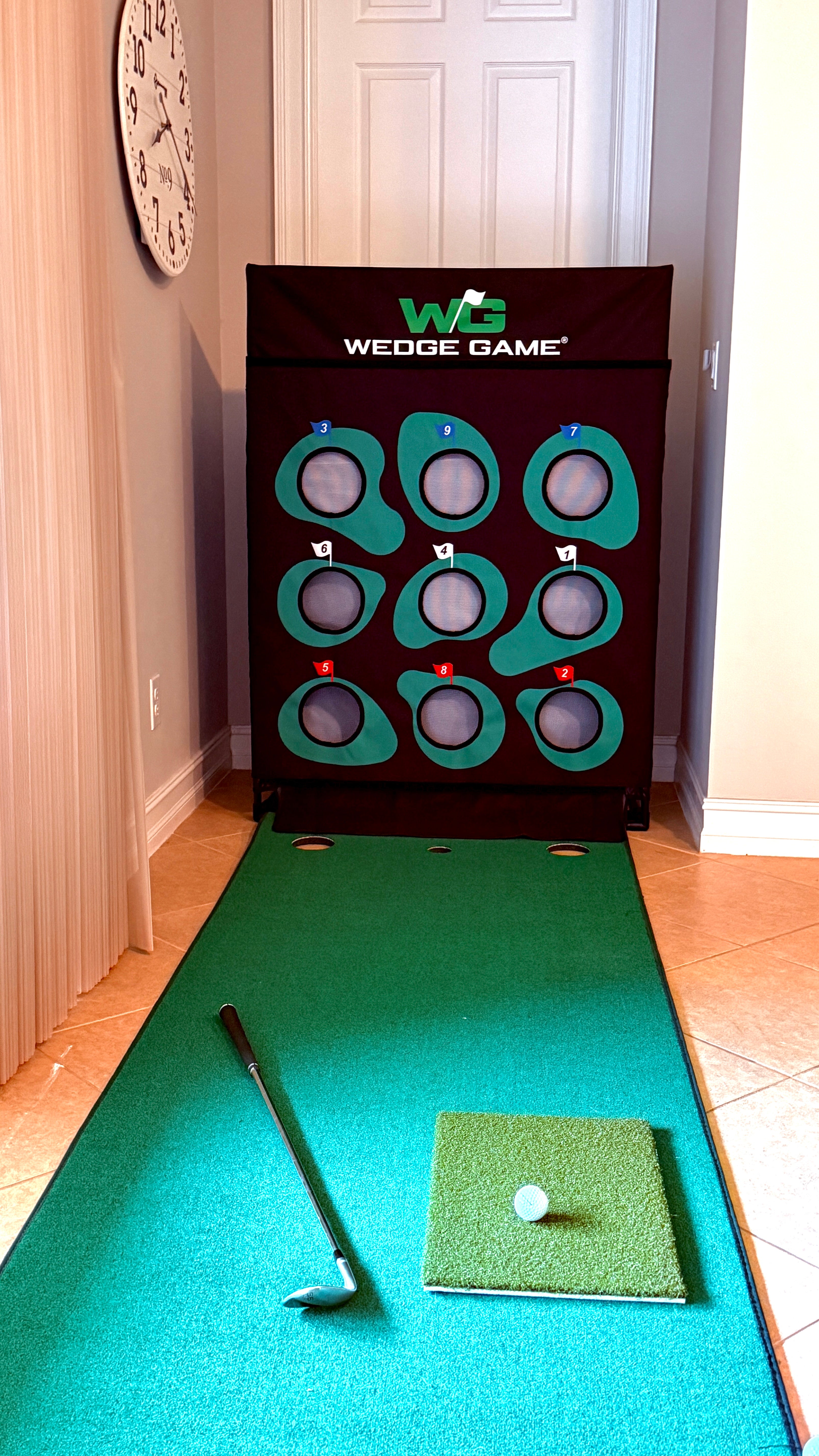 Wedge Game in front of a door in  home with a wedge, golf ball and chipping mat